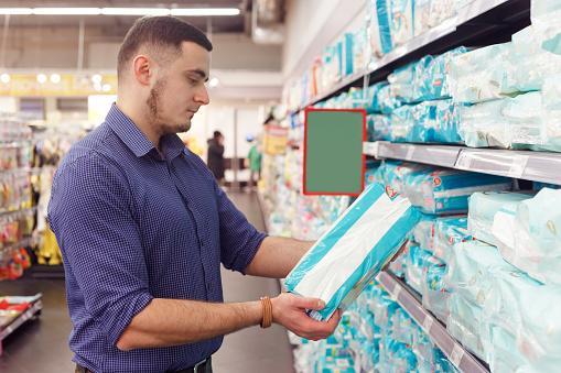 https://media.istockphoto.com/id/1212061976/photo/man-with-diaper-pack-in-supermarket-reading-product-information.jpg?b=1&s=170667a&w=0&k=20&c=GChfP2_Ukx3s8X3Ozxg9jrTmPYu_UxumX5iMz2EG4k8=