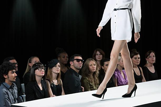 Audience watching model on catwalk at fashion show, low section  New York Fashion Week  Runways  stock pictures, royalty-free photos & images