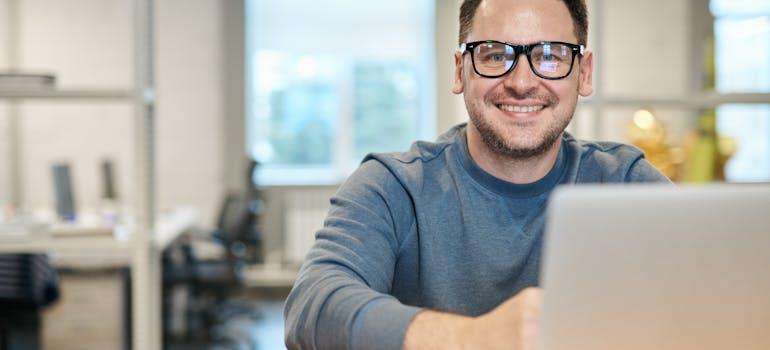 a man working on his laptop and smiling